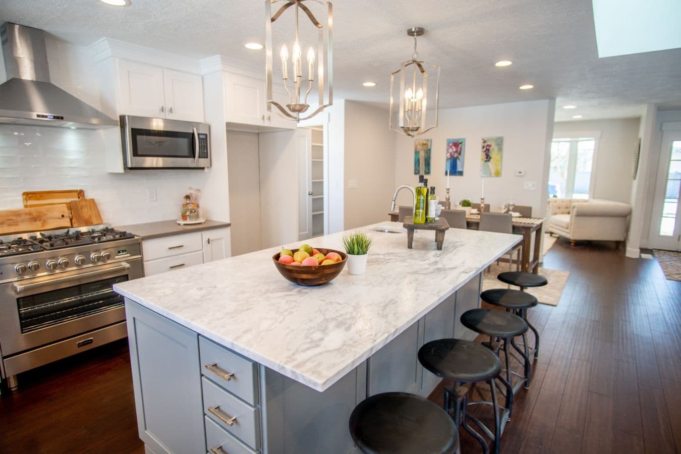 Frantz home remodeling large white kitchen island with gold hanging chandeliers and black bar stools