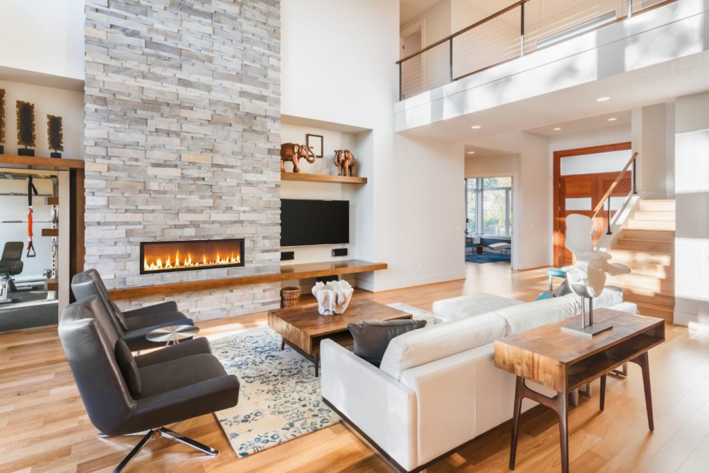 modern home living room living room seating hardwood floors large stone glass front fireplace